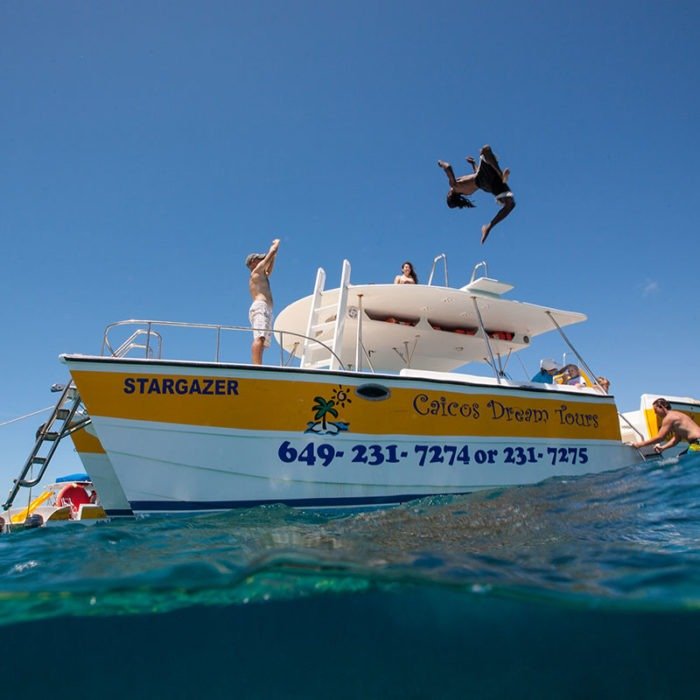 Diving into water off of Caicos Dream Tours boat