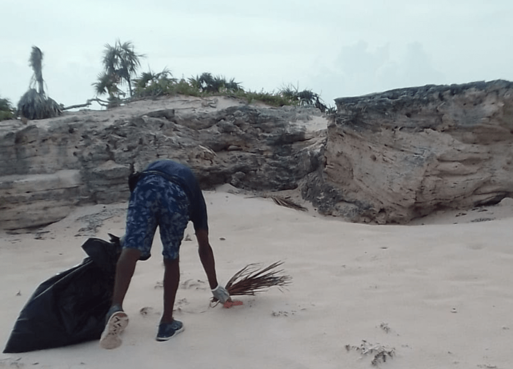 member of Caicos Dream Tours during an iguana island clean ups