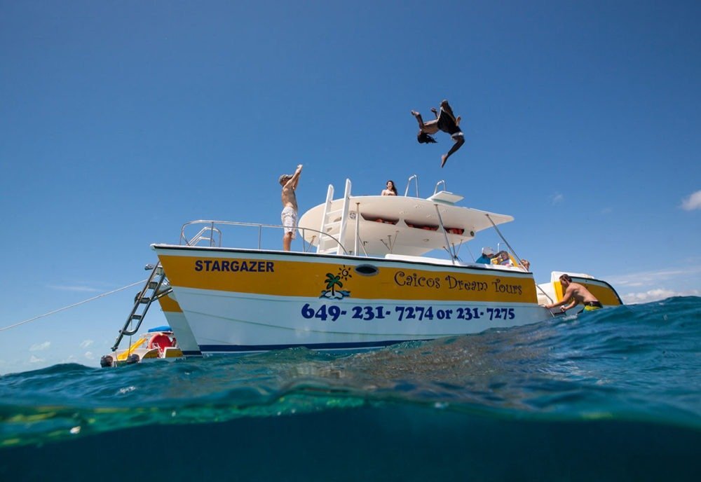People on a boat named Stargazer, someone jumping into the water.