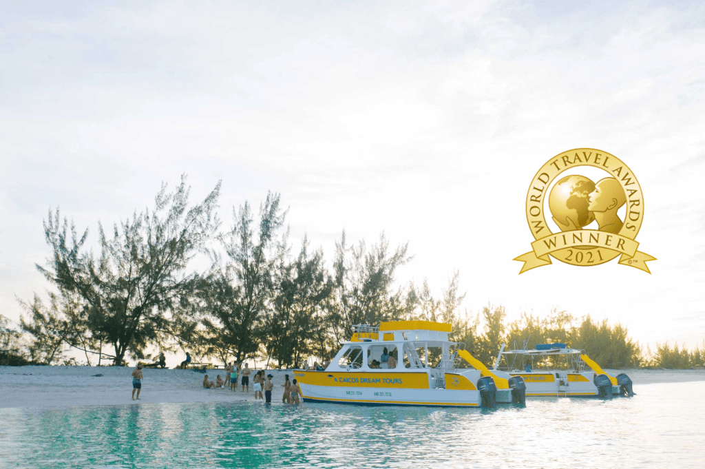 Two yellow boats near a beach with people, trees, and a 'World Travel Awards 2021' badge.