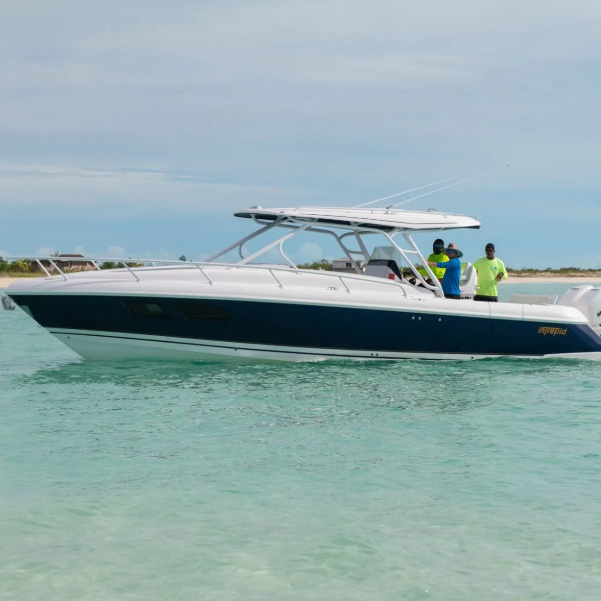 White and blue motorboat on calm water with three people on board.