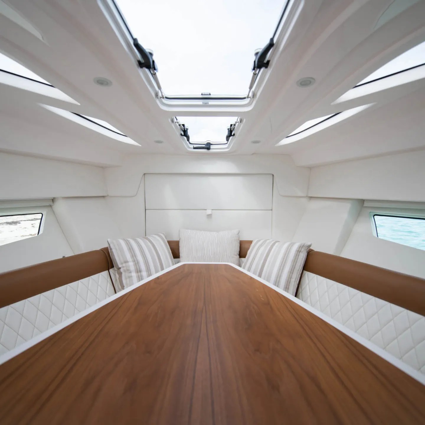 Interior of a yacht with a wood table and cushioned seating.