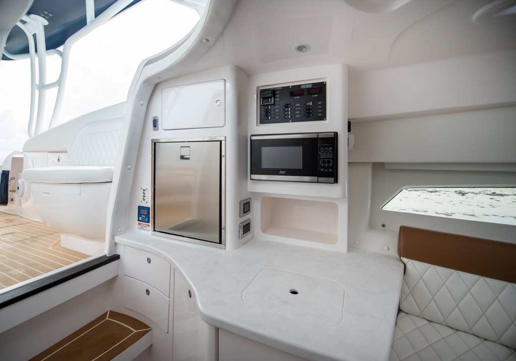 Boat kitchenette with microwave, fridge, and seating area.