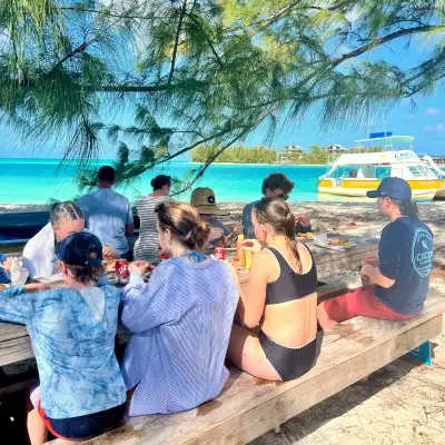 a group of people sitting next to a body of water