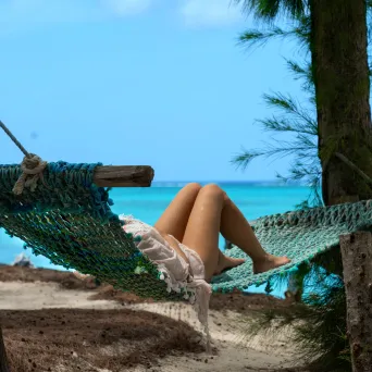 a woman sitting on a bench next to a body of water