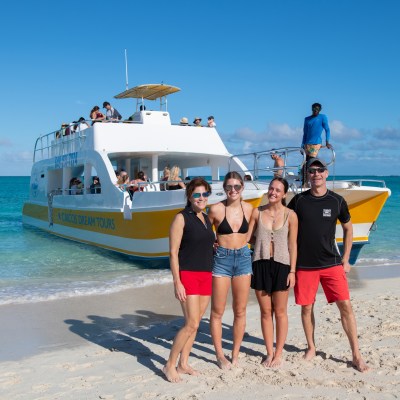 a group of people standing on top of a sandy beach