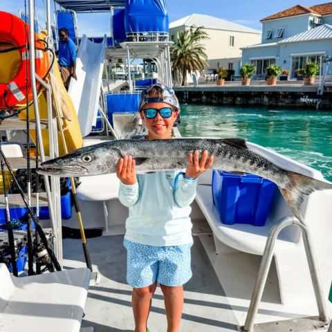 a boy standing in front of a boat