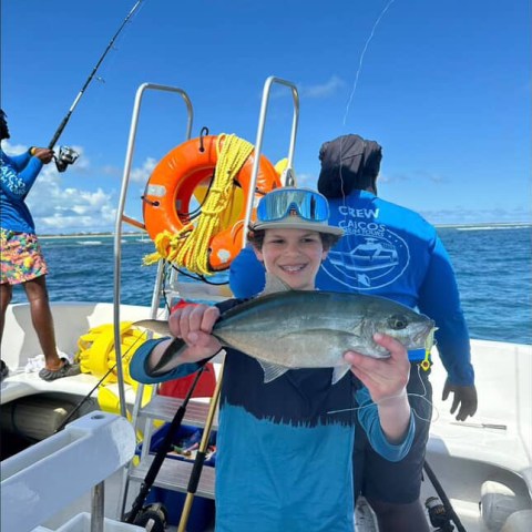 a person holding a fish in the water