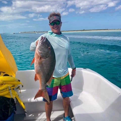 a man holding a fish in the water