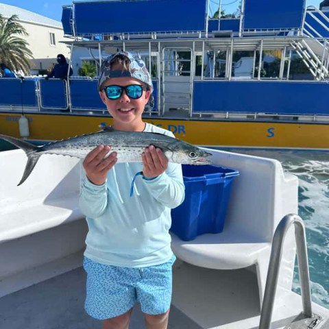 a person in a blue shirt standing in front of a boat