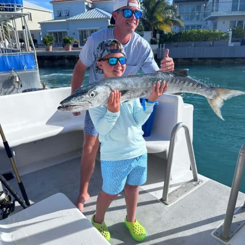 a man holding a fish on a boat