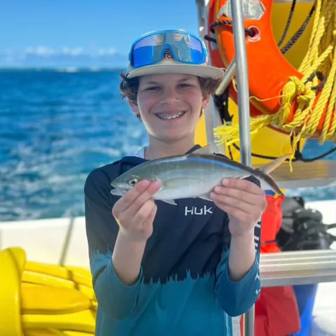 a boy sitting on a boat in the water
