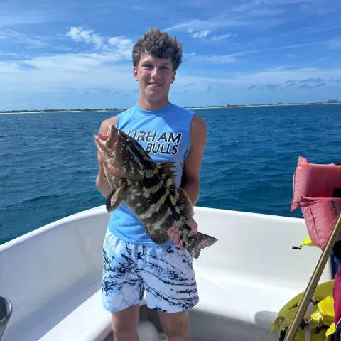 a person standing in front of a boat next to a body of water