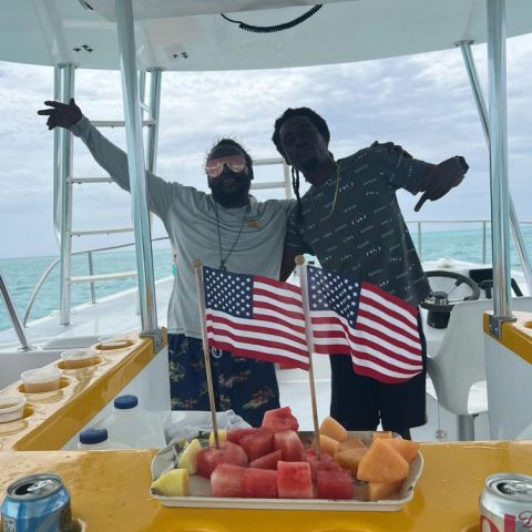 a group of people sitting at a table in front of a boat