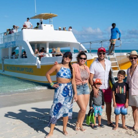 a group of people standing on top of a sandy beach