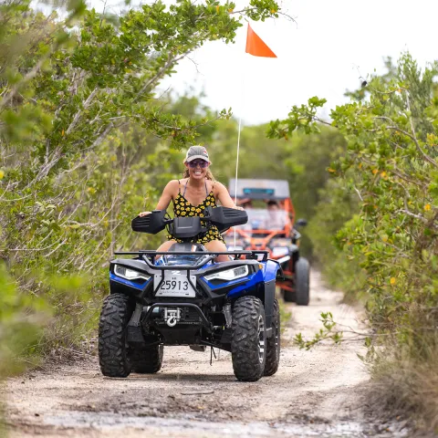 a man riding a motorcycle down a dirt road